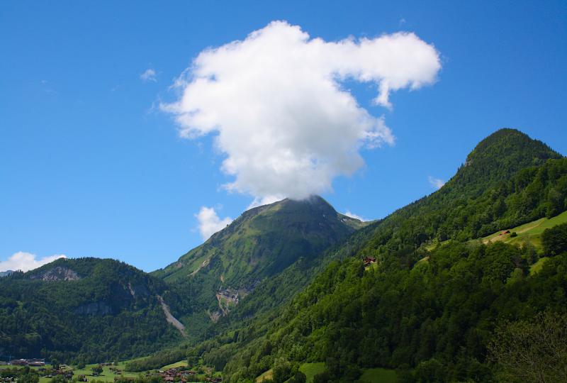 Lungern: bewaldete Hänge und Felsen mit Wolke